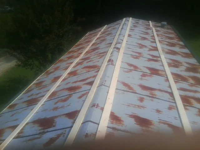 Rusted metal roof panels with new wood purlins before replacement — Storm Damage Roof Repair in Saint Donatus by Roofing Brothers